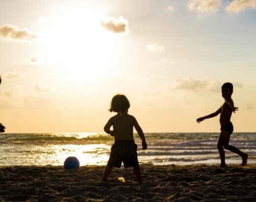 silhouette of three children on beach